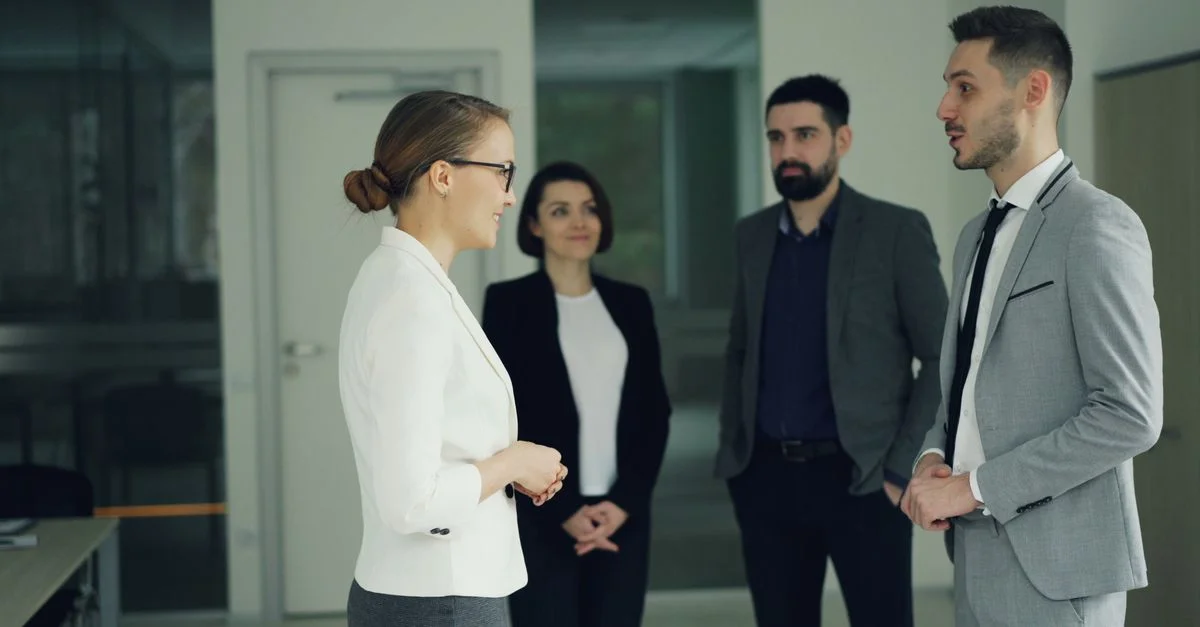 Grupo de profesionales en traje formal teniendo una discusión en un entorno de oficina moderna.