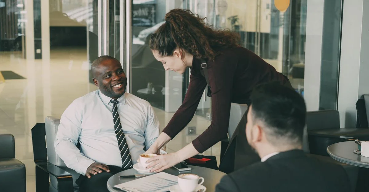 Profesionales de negocios disfrutando de café durante una reunión casual en un café.