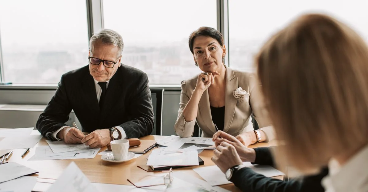 Profesionales de negocios discutiendo durante una reunión en un entorno de oficina moderna.