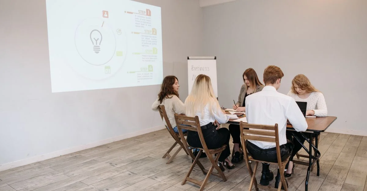 Grupo de jóvenes profesionales colaborando en un entorno de oficina luminosa.