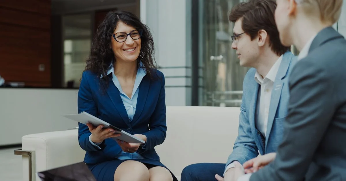 Profesionales discutiendo estrategias de negocio en un entorno de oficina corporativa.