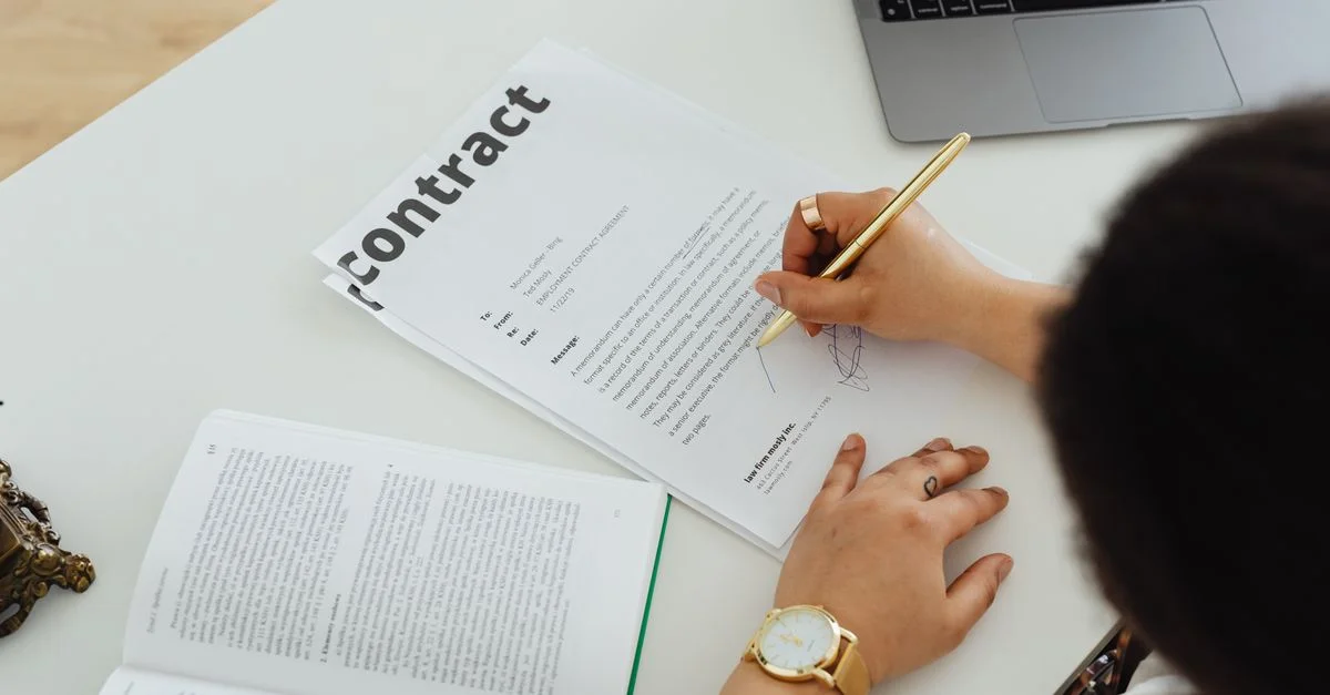 Profesional firmando un contrato comercial en una configuración de escritorio moderna para el trabajo de oficina.
