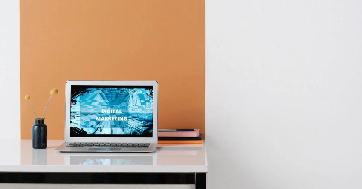 Un espacio de trabajo limpio y moderno con un portátil que muestra marketing digital en la pantalla, ideal para uso empresarial.